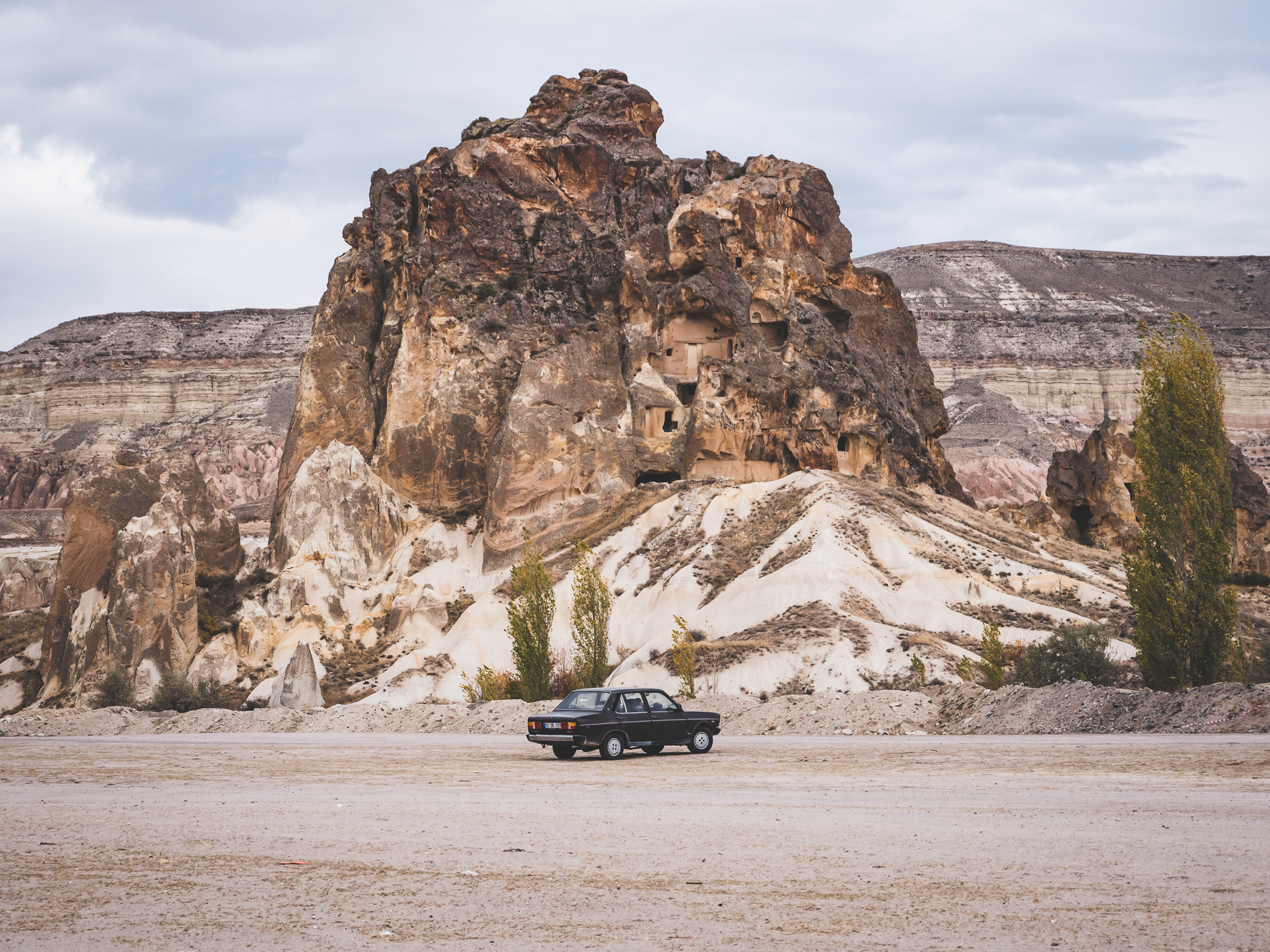 paysage typique quand on visite la cappadoce : une vieille voiture de collection devant un paysage troglodyte