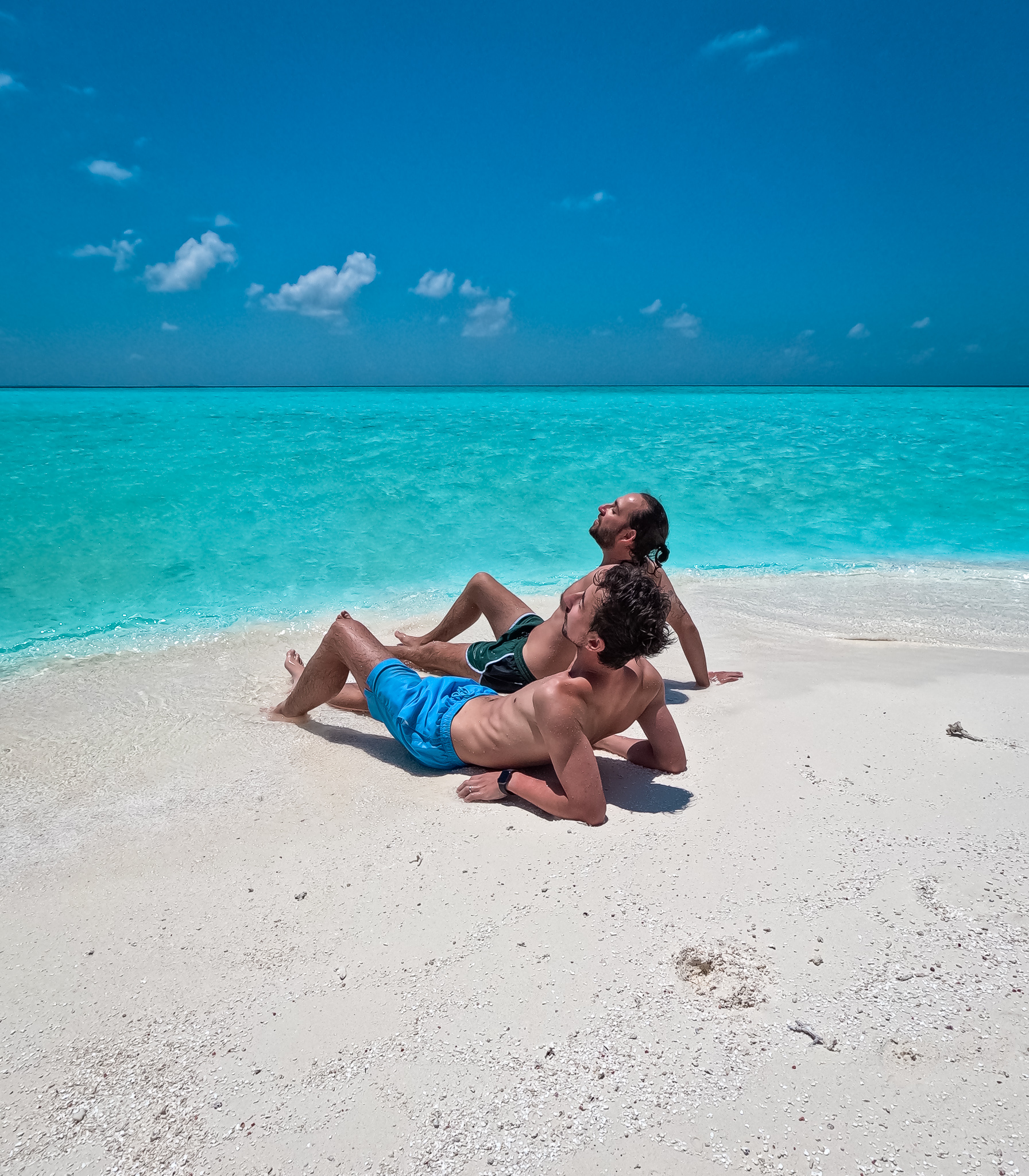 Deux hommes sur un banc de sable aux Maldives.