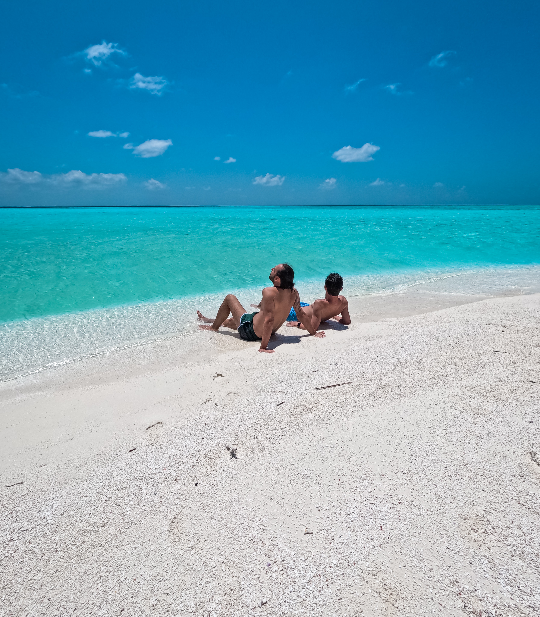 Deux hommes sur un banc de sable aux maldives